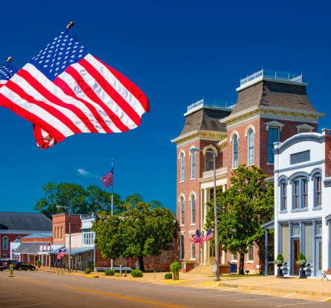 American Flags flying in a small town square.